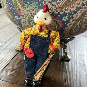 Whimsical rooster farmer in overalls and floral shirt with broom